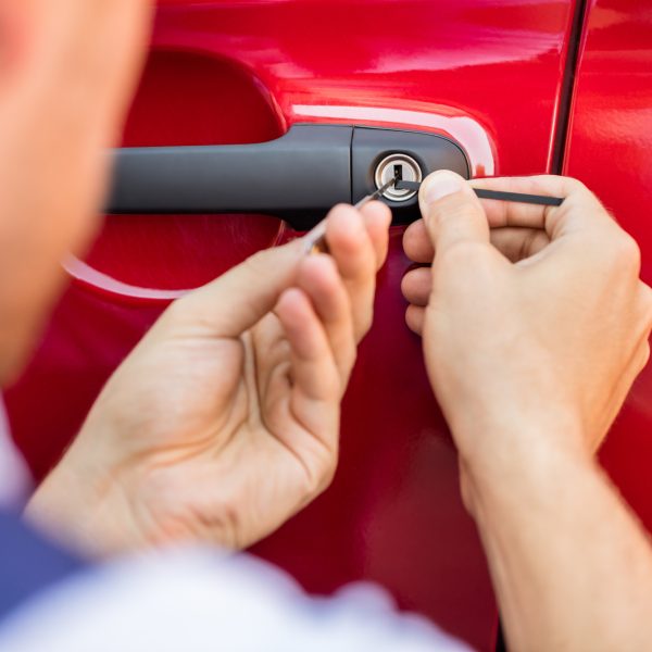 Close-up Of Person's Hand Opening Car Door With Lockpicker